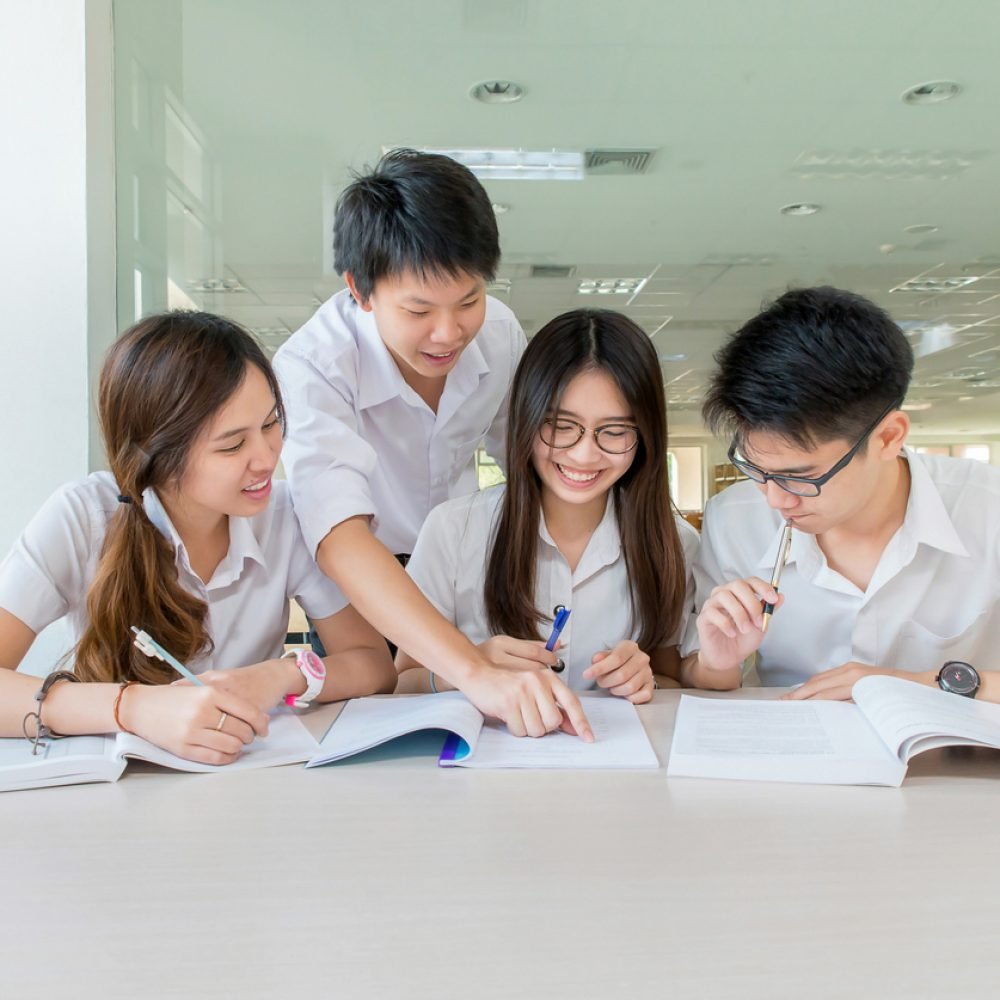 Group of asian students in uniform studying together at classroom